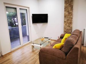 a living room with a couch and a tv at Apartment 4* with big terasse in Selce