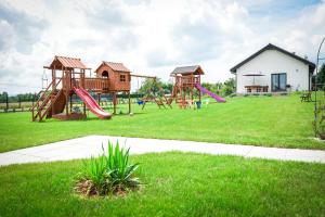 a playground with two slides and a play yard at Słoneczne Wzgórze Zator in Zator +208 photos
