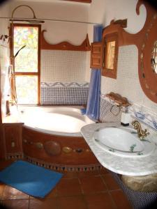 a bathroom with a tub and a sink at Posada Del Río Carbo in Villahermosa del Río