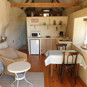 una pequeña cocina con mesa y microondas en Gîte de la Founauderie, en Roncey