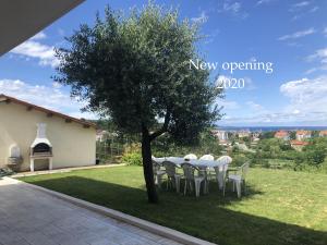 a table and chairs under a tree in a yard at Residence Villa Fiore Portorož in Portorož