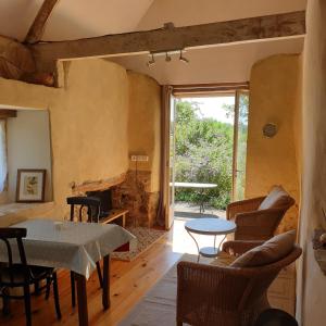 sala de estar con mesa y chimenea en Gîte de la Founauderie, en Roncey