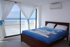 a bedroom with a bed and a view of the ocean at Casa Blanca Hotel Boutique in Santa Marianita
