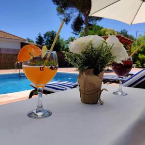 a table with two glasses of orange juice and a vase of flowers at Casa Navajas in Jérica