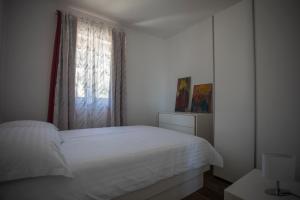 a bedroom with a white bed and a window at Blueberry in Bol