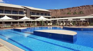 
a swimming pool with a large swimming pool in front of a building at Crowne Plaza Alice Springs Lasseters, an IHG Hotel in Alice Springs
