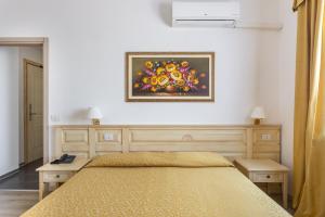 a bedroom with a bed and a painting on the wall at Rodia Inn in Oristano