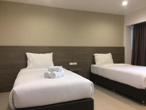 ein Hotelzimmer mit zwei Betten mit Handtüchern darauf in der Unterkunft 14 Resort in Bangkok