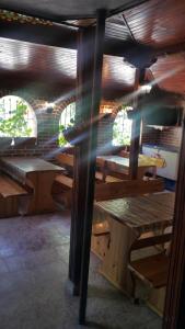 Habitación con mesas de madera y bancos en un edificio en На гости при Силвия en Obzor