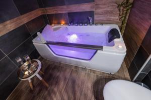 a bath tub with a purpleapor at NAR Royalton Accommodation in Niš