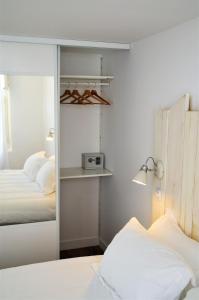 a bedroom with two beds and a mirror at Maison d'hôtes City Break MIRADOUR in Bayonne