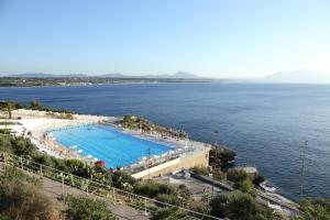 - une grande piscine à côté d'une grande étendue d'eau dans l'établissement Perla Del Golfo Resort, à Terrasini