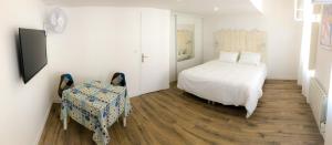 a bedroom with a bed and a table and a chair at Maison d'hôtes City Break MIRADOUR in Bayonne