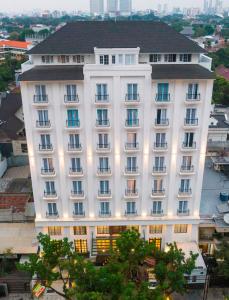 a large white building with many windows at Jambuluwuk Thamrin Hotel in Jakarta