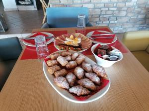 a table with a plate of donuts on a table at Nefeli Apartments in Leptokarya
