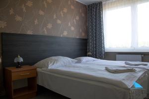 een slaapkamer met een groot bed en een raam bij Na Skarpie in Olsztyn