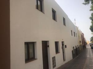 a white building with black windows on a street at Fuerteventura Family Luxury in Morro del Jable
