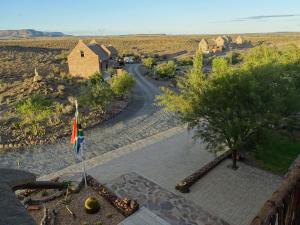 a view of a road with a house and a flag at Teri-Lemveli Lodge in Beaufort West