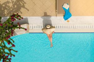 a woman in a hat standing in a swimming pool at Rodos Park in Rhodes Town