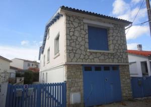 a house with a blue gate and a blue garage at CENTRE CHATELAILLON GRAND LOFT ** 100m DE LA PLAGE in Châtelaillon-Plage