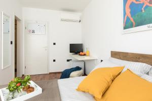 biała sypialnia z łóżkiem i biurkiem w obiekcie Žardin w mieście Punat