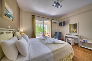 1 dormitorio con 1 cama con sábanas blancas y ventana en Paxos Club Resort & SPA, en Gáios
