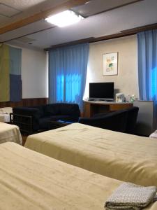 a hotel room with two beds and a desk with a computer at Hotel Civic Inn Sayama in Sayama