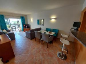 Una sala de estar con mesa y sillas y una cocina. en One Bedroom Apartment with Stunning Views, en Alvor