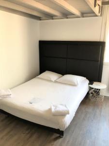 ボルドーにあるStudios dans l'hyper centre Bordeauxのベッドルーム(白い大型ベッド1台、黒いヘッドボード付)