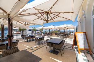 a patio area with tables, chairs and umbrellas at BO Hotel Palazzo in Poreč