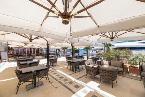 an outdoor patio with tables and chairs and umbrellas at BO Hotel Palazzo in Poreč
