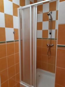 e bagno con doccia e piastrelle bianche e arancioni. di Apartmány Jarmila a Dolní Moravice