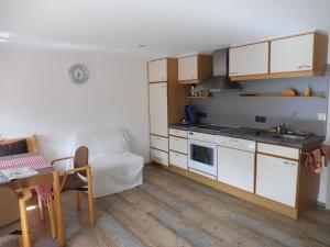 a kitchen with white cabinets and a table and a dining room at Gästehaus Grath in Lindenberg im Allgäu