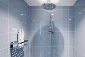 a blue tiled bathroom with a shower at Hotel 171 in Rotterdam