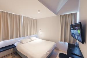 a bedroom with a bed and a flat screen tv at Hotel 171 in Rotterdam