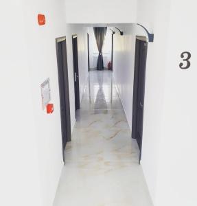 a hallway with black doors and marble floors at ZETH HOUSE in Mamaia Nord