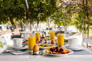 a table topped with plates of food and orange juice at Hotel Kavala - Boutique Hotel in Prinos