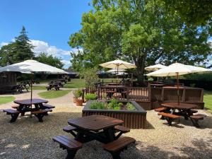 a group of picnic tables and umbrellas in a park at The Congresbury Arms in Congresbury