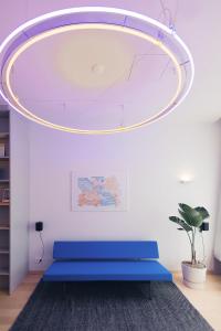 a room with a blue bench under a circular light at Hotel 171 in Rotterdam