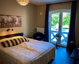 a bedroom with a bed and a sliding glass door at Taastrup Park Hotel in Tåstrup