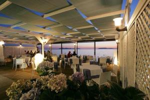 a restaurant with tables and chairs and a view of the ocean at Sunset Beach in Marausa