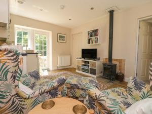 a living room with a couch and a tv at Fieldfare Lodge in Leyburn