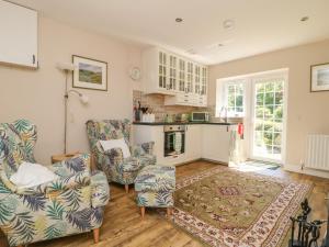 a living room with two chairs and a fireplace at Fieldfare Lodge in Leyburn