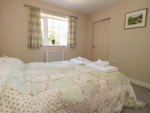 a bedroom with a bed with a quilt on it at Fieldfare Lodge in Leyburn