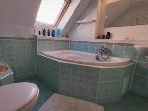 a bathroom with a tub and a toilet and a sink at Chalupa v Hliníku in Hliník nad Hronom