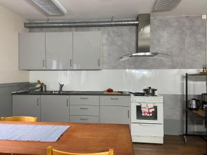 eine Küche mit weißen Geräten und einem Holztisch in der Unterkunft Vojakkala Vandrarhem in Haparanda
