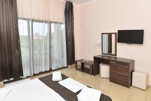 a hotel room with a bed and a flat screen tv at Hotel Bella Vista in Eforie Nord