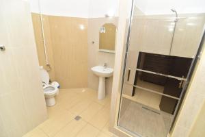a bathroom with a shower and a toilet and a sink at Hotel Bella Vista in Eforie Nord