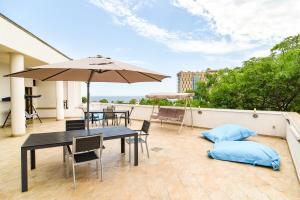 a patio with a table and an umbrella on a balcony at Hotel Bella Vista in Eforie Nord