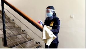 a person wearing a mask standing next to a staircase at Sandy's Homestay in Banyuwangi